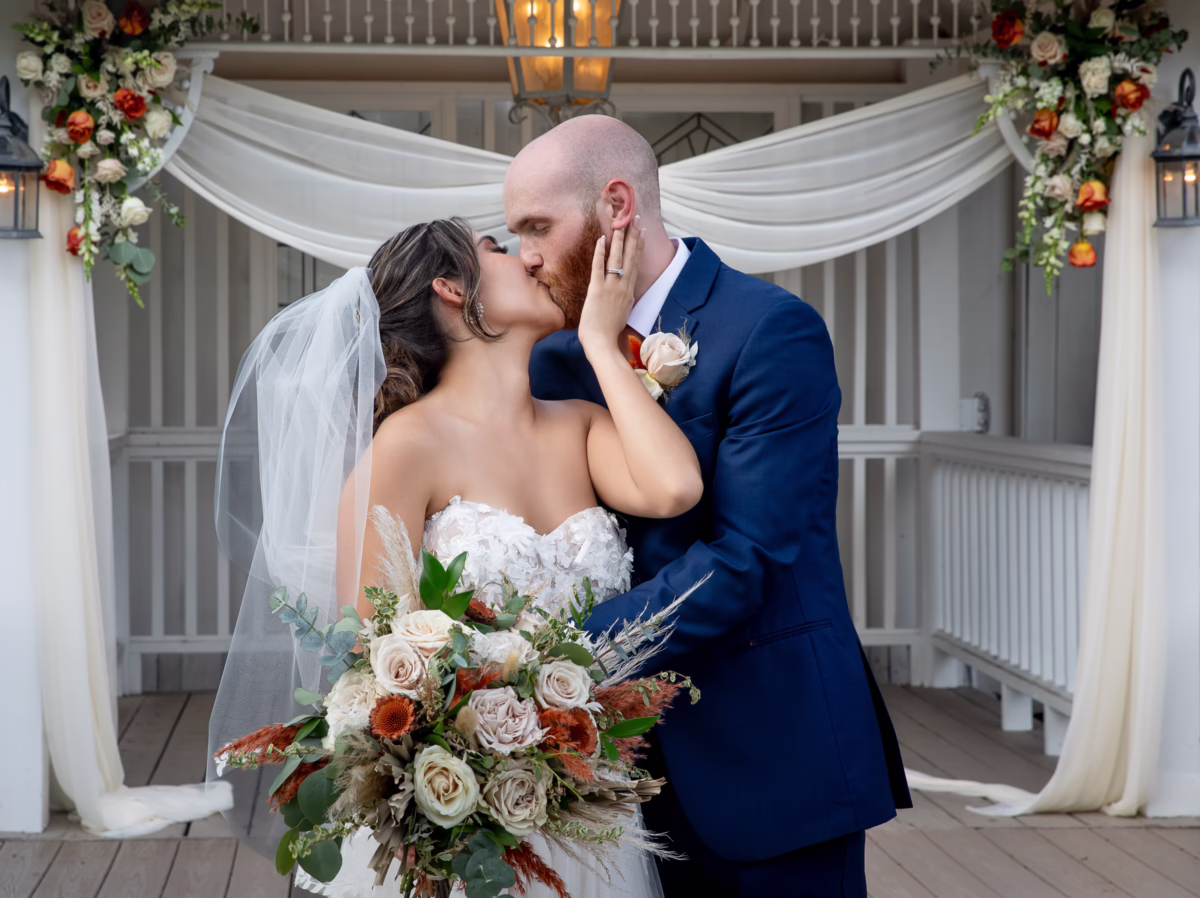 orlando celebration gardens wedding ceremony kiss floral arch winter park venue - Weddings Bride and groom sharing their first kiss under elegant white fabric and floral arch at Orlando Celebration Gardens wedding ceremony in Winter Park Florida