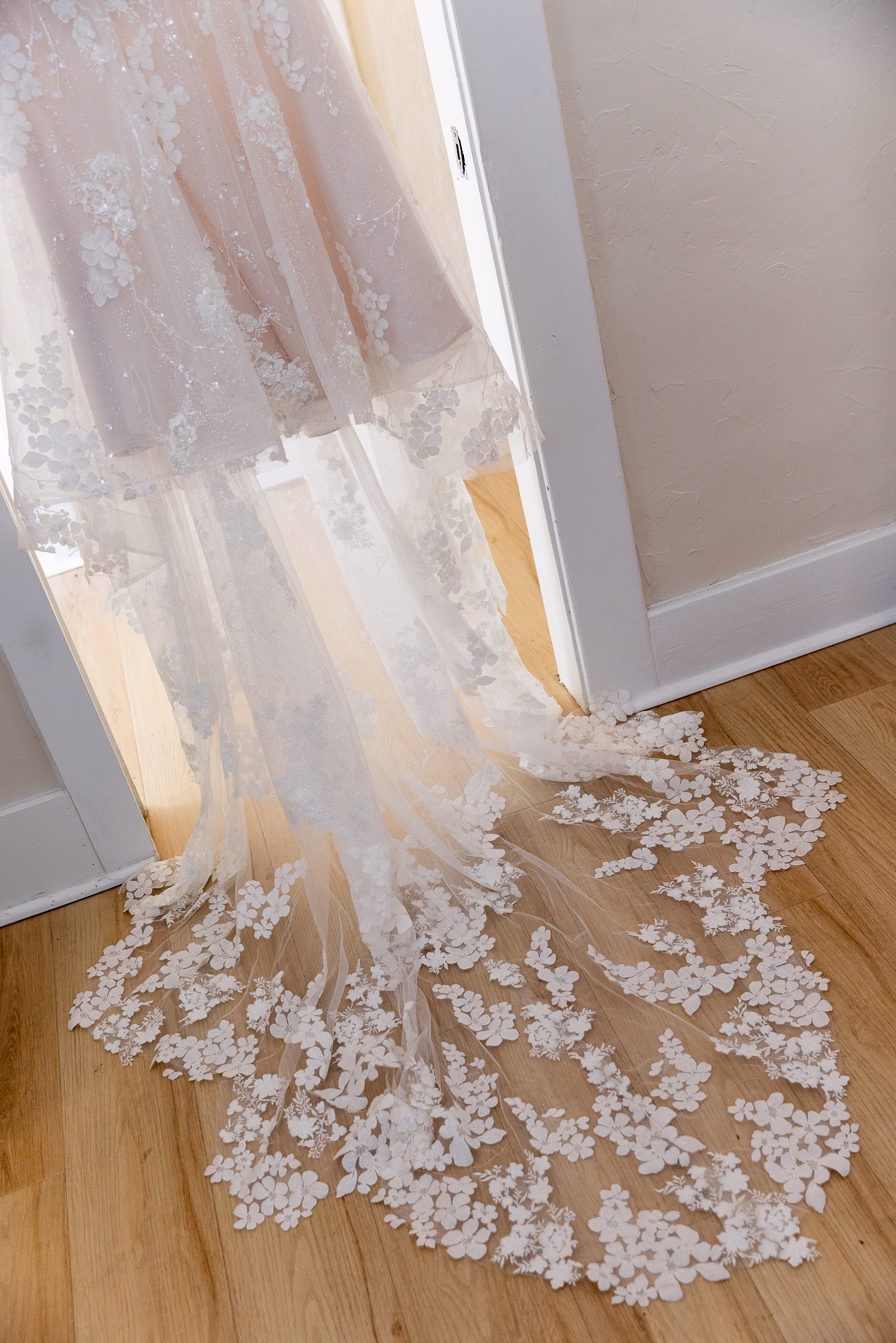 Delicate floral applique lace wedding dress train pooling on hardwood floor at Orlando Celebration Gardens wedding venue in Orlando Florida